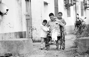 10岁的李雪新雨和5岁的李亚娜，奋力推着轮椅，陪爸爸去学针灸